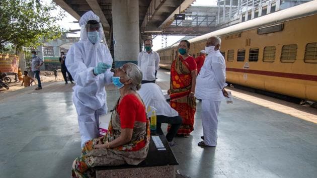 A health care worker collects swab sample of the passengers at Dadar station in Mumbai on Friday.(Pratik Chorge/HT Photo)