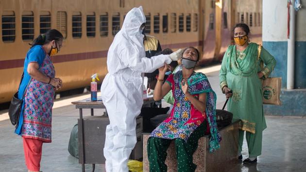 A health care worker collects swab sample of the passengers at Dadar station in Mumbai on Friday.(Pratik Chorge/HT Photo) A health care worker collects swab sample of the passengers at Dadar station in Mumbai on Friday.(Pratik Chorge/HT Photo)