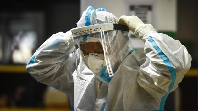 A doctor puts on protective gear before entering a Covid Care Ward at CWG Covid-19 Care Complex, in New Delhi on Friday. (Sanchit Khanna/HT PHOTO) A doctor puts on protective gear before entering a Covid Care Ward at CWG Covid-19 Care Complex, in New Delhi on Friday. (Sanchit Khanna/HT PHOTO)