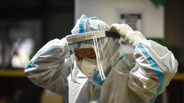 A doctor puts on protective gear before entering a Covid Care Ward at CWG Covid-19 Care Complex, in New Delhi, India. (Sanchit Khanna/HT PHOTO) A doctor puts on protective gear before entering a Covid Care Ward at CWG Covid-19 Care Complex, in New Delhi, India. (Sanchit Khanna/HT PHOTO)
