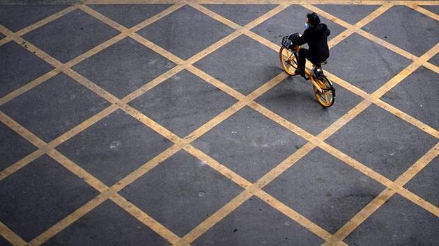 A person wearing a mask rides a bicycle of bike-sharing service on a street, almost a year after the start of the coronavirus disease (Covid-19) outbreak, in Wuhan, Hubei province, China. (Reuters) A person wearing a mask rides a bicycle of bike-sharing service on a street, almost a year after the start of the coronavirus disease (Covid-19) outbreak, in Wuhan, Hubei province, China. (Reuters)
