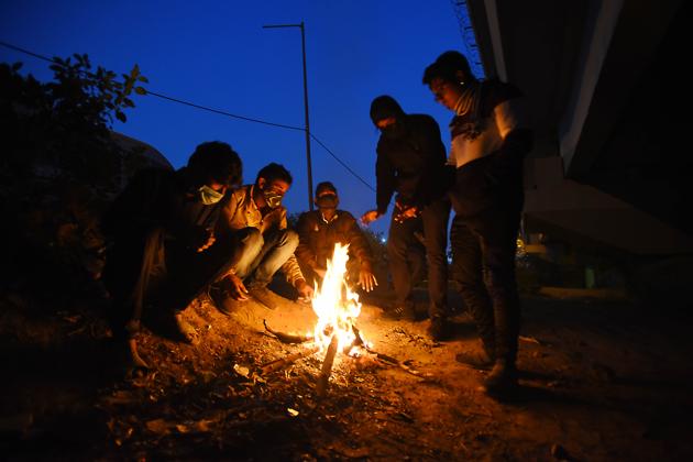 People huddled around a bonfire under a flyover on a winter evening at Yamuna Bank in New Delhi on December 17. As temperatures continue to drop in Northern India, Delhi recorded its season’s lowest temperature yet, at 3.4 degrees Celsius, according to the India Meteorological Department (IMD) on December 20. (Raj K Raj / HT Photo)