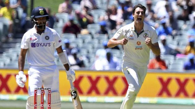 Australia's Pat Cummins, right, celebrates the wicket of India's Cheteshwar Pujara, left, on the third day of their cricket test match at the Adelaide Oval in Adelaide, Australia, Saturday, Dec. 19, 2020. (AP Photo/David Mairuz)(AP)