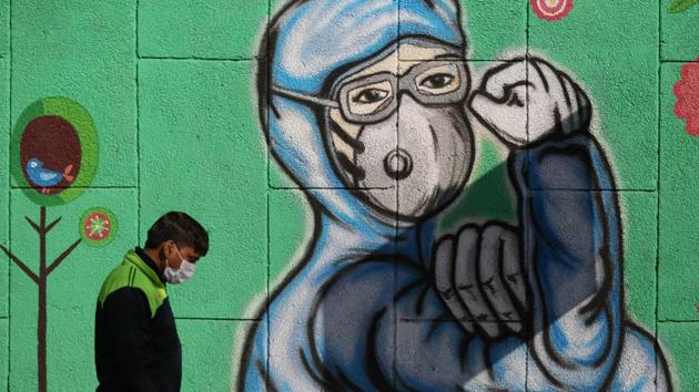 A pedestrian walks past a mural showing a coronavirus front-line worker in Okhla, New Delhi on December 20. The daily positivity rate in Delhi has now been below 5% for 18 days, HT reported. (Sanchit Khanna / HT Photo) A pedestrian walks past a mural showing a coronavirus front-line worker in Okhla, New Delhi on December 20. The daily positivity rate in Delhi has now been below 5% for 18 days, HT reported. (Sanchit Khanna / HT Photo)