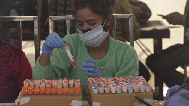 A health worker preserves a swab sample collected at Anand Vihar ISBT in New Delhi on December 20. As new infections continued to fall the positivity rate remained below 2% for the sixth consecutive day on December 20. (Vipin Kumar / HT Photo) A health worker preserves a swab sample collected at Anand Vihar ISBT in New Delhi on December 20. As new infections continued to fall the positivity rate remained below 2% for the sixth consecutive day on December 20. (Vipin Kumar / HT Photo)