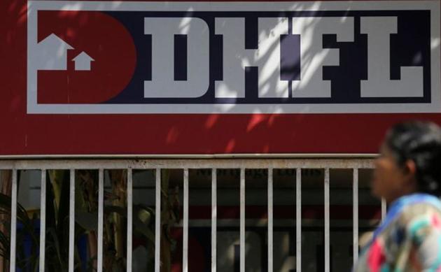 A woman walks past a signboard of Dewan Housing Finance Corporation Ltd. (DHFL) outside its office on the outskirts of Mumbai.(REUTERS)