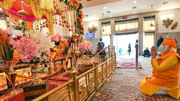 PM Modi, wearing a head scarf, was seen praying and also interacting with other worshippers. Some people also clicked pictures with the PM. (PTI Photo) PM Modi, wearing a head scarf, was seen praying and also interacting with other worshippers. Some people also clicked pictures with the PM. (PTI Photo)