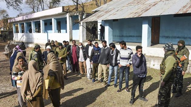 Poonch: Security personnel stand guard as residents queue to cast their votes during re-polling of DDC elections, at a booth in Poonch district, Monday, Dec. 21, 2020. (PTI Photo) Poonch: Security personnel stand guard as residents queue to cast their votes during re-polling of DDC elections, at a booth in Poonch district, Monday, Dec. 21, 2020. (PTI Photo)