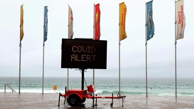 An electronic board displays a covid alert at a deserted Manly Beach in Sydney on December 21. Australia confirmed on December 21 that it has detected two cases of a fast-spreading new coronavirus strain. (Brendon Thorne / Bloomberg)