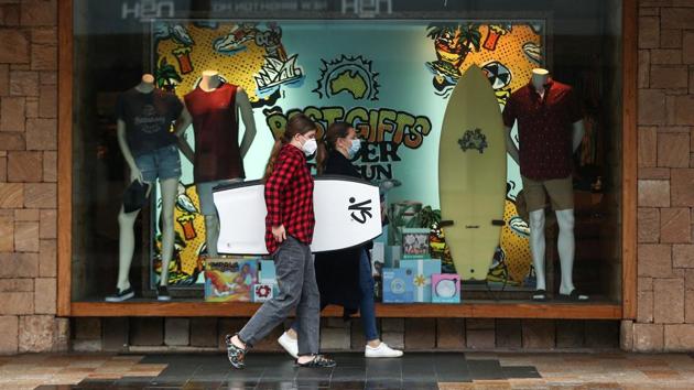 Pedestrian wearing face masks walk past a store in the Manly suburb of Sydney on December 21. According to Reuters, New South Wales officials stressed that no people infected with the new strain were believed to be circulating in the community. (Brendon Thorne / Bloomberg) 
