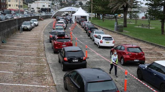 Vehicles queue at the Bondi Beach drive-through Covid-19 testing centre in Sydney on December 21. In a bid to contain the spread, NSW has opened dozens of new testing sites, some running 24-hours a day.  (Loren Elliott / REUTERS) 