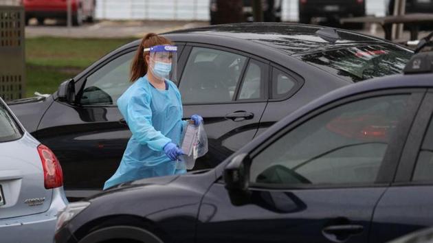 A medical personnel approaches a vehicle to collect a swab sample at the Bondi Beach drive-through Covid-19 testing centre in Sydney on December 21. A record of over 38,000 tests were conducted between December 20 and 21, Reuters reported citing NSW health officials. (Loren Elliott / REUTERS) 