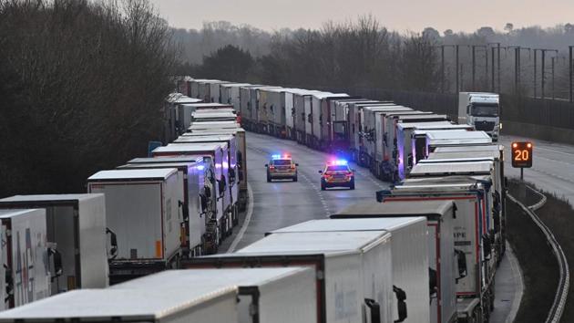 Police cars patrol as freight lorries are backed up for miles on the highway leading to the port of Dover in England on December 22. The critical south coast port at Dover said on December 20 it was closing one of the most important trade arteries with mainland Europe to all freight and passengers traffic due to the French border restrictions "until further notice". (Justin Tallis / AFP) Police cars patrol as freight lorries are backed up for miles on the highway leading to the port of Dover in England on December 22. The critical south coast port at Dover said on December 20 it was closing one of the most important trade arteries with mainland Europe to all freight and passengers traffic due to the French border restrictions "until further notice". (Justin Tallis / AFP)