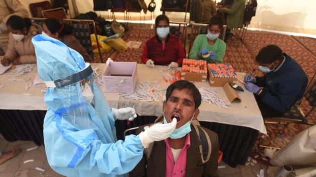 A health worker in PPE collects a swab sample from a traveller at Anand Vihar ISBT during coronavirus screening, in New Delhi, India, on Sunday, December 20, 2020. (Vipin Kumar/HT PHOTO) A health worker in PPE collects a swab sample from a traveller at Anand Vihar ISBT during coronavirus screening, in New Delhi, India, on Sunday, December 20, 2020. (Vipin Kumar/HT PHOTO)