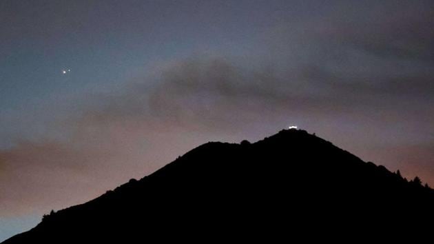 Jupiter and Saturn appear about one-tenth of a degree apart during an astronomical event known as a Great Conjunction above Mt. Tamalpais in Larkspur, California.(AP)