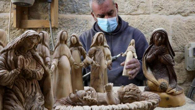 A carpenter carves religious figurines from olive wood at a shop near the Church of the Nativity, in the West Bank city of Bethlehem, Palestine on December 21. (Hazem Bader / AFP) A carpenter carves religious figurines from olive wood at a shop near the Church of the Nativity, in the West Bank city of Bethlehem, Palestine on December 21. (Hazem Bader / AFP)