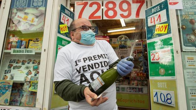A lottery seller celebrates after selling the first prize of Spain’s Christmas lottery draw El Gordo (the Fat One) in Vigo on December 22. Travel restrictions, curfews and public gathering limit Spain will differ from region to region and are also subject to change if infection rates rise. (AFP) A lottery seller celebrates after selling the first prize of Spain’s Christmas lottery draw El Gordo (the Fat One) in Vigo on December 22. Travel restrictions, curfews and public gathering limit Spain will differ from region to region and are also subject to change if infection rates rise. (AFP)
