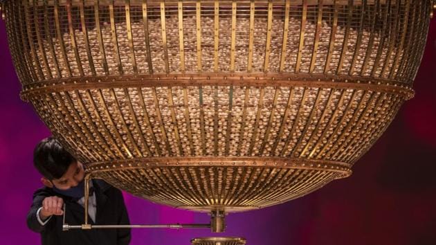 A ball bearing a ticket number falls from a giant drum at Madrid's Teatro Real opera house during Spain's bumper Christmas lottery draw known as El Gordo, or The Fat One, in Madrid, Spain.(AP)