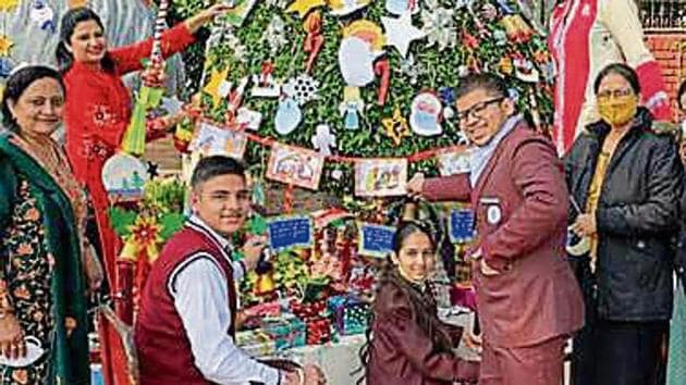 Children, along with the faculty, decorating a tree. (HT) Children, along with the faculty, decorating a tree. (HT)