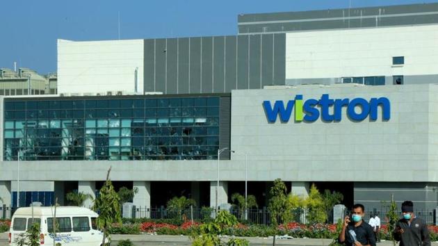 Men wearing protective face masks walk past broken windows of a facility run by Wistron Corp in Narsapura near the southern city of Bengaluru. (REUTERS) Men wearing protective face masks walk past broken windows of a facility run by Wistron Corp in Narsapura near the southern city of Bengaluru. (REUTERS)