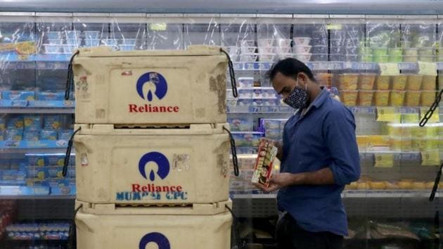 A customer wearing a protective mask checks a dairy product inside a superstore of Reliance Industries Ltd, in Mumbai.(REUTERS)