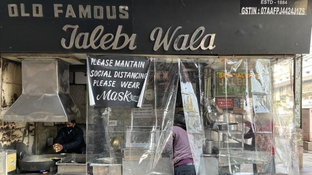 The legendary Old Famous Jalebi Wala shop in Chandni Chowk is screened off with a plastic curtain on an early December morning. A special poster cane up three weeks ago asking customers to maintain social distancing. The masked cook, Vicky, has just finished deep-frying the day’s first batch of jalebis. The shop stayed closed for two months during the lockdown and reopened in early June. (Mayank Austen Soofi / HT Photo)