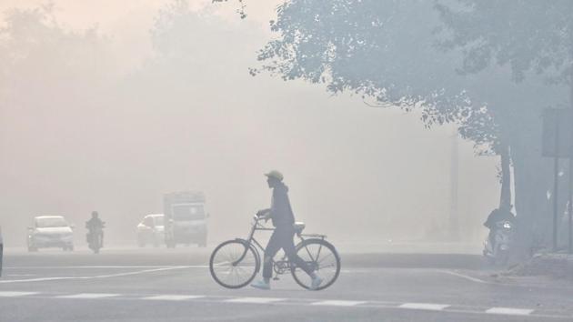 A cyclist crosses a road in Azadpur, New Delhi on December 23. Delhi’s air quality had reached the severe zone on December 5, when the overall AQI reading of the city was recorded at 404. (Sanchit Khanna / HT Photo)