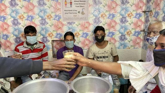 Masked customers at a small roadside tea shop in Seelampur on a cool November morning. A Delhi Government-issued poster on the wall reads: “Not wearing mask is not a heropanti...” But, of course, the customers were obliged to take off their mask to dunk down their chai. (Mayank Austen Soofi / HT Photo) Masked customers at a small roadside tea shop in Seelampur on a cool November morning. A Delhi Government-issued poster on the wall reads: “Not wearing mask is not a heropanti...” But, of course, the customers were obliged to take off their mask to dunk down their chai. (Mayank Austen Soofi / HT Photo)