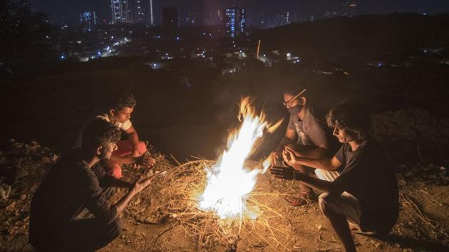Youngsters sit around a bonfire at Bhandup, on Monday. (Pratik Chorge/HT Photo) Youngsters sit around a bonfire at Bhandup, on Monday. (Pratik Chorge/HT Photo)