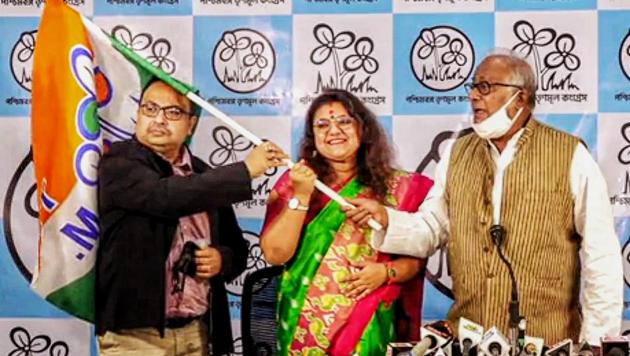 Kolkata: Sujata Mondal (C), wife of BJP MP Saumitra Khan, holds the Trinamool Congress party flag after joining TMC in the presence of party MP Sougata Roy(R) and leader Kunal Ghosh, in Kolkata, Monday, Dec. 21, 2020.(PTI)