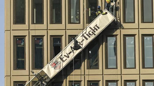 A worker stands on the end of a dangling scaffold as he waits to be rescued following an explosion at Baltimore Gas and Electric's offices.(AP) A worker stands on the end of a dangling scaffold as he waits to be rescued following an explosion at Baltimore Gas and Electric's offices.(AP)