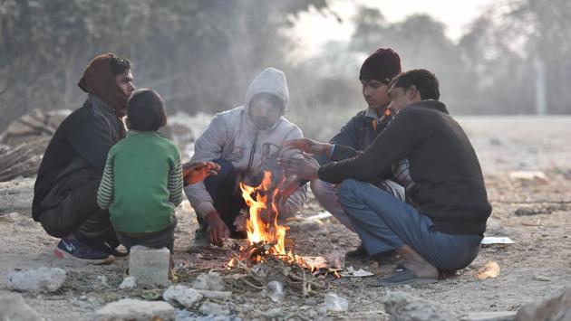 People warm themselves around a bonfire near the Yamuna riverbank in Mayur Vihar, New Delhi on December 21. According to India Meteorological Department (IMD), the temperature is expected to dip and reach around 4 degrees Celsius by December 24. (Raj K Raj / HT Photo)