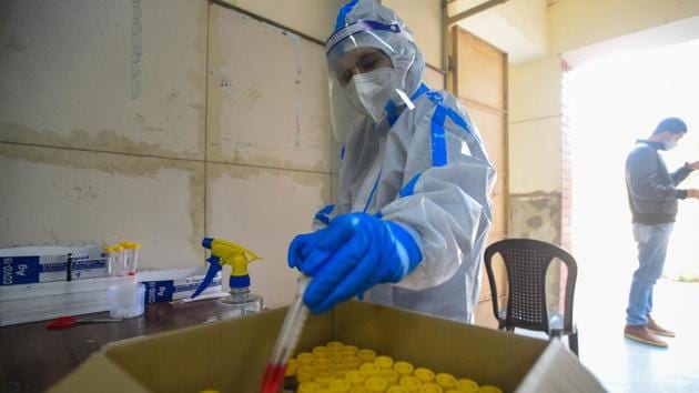 A health worker in PPE preserves a swab sample taken for coronavirus screening in New Delhi on December 22. India reported 24,712 fresh Covid-19 cases over the previous 24 hour period, according to the Union health ministry, taking the total tally on December 24 to 10,123,778. The number of fresh infections registered a 3% rise from December 23 when 23,950 new cases were registered. (Amal KS / HT Photo)