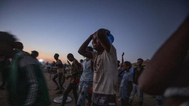 Men who fled the conflict in Ethiopia's Tigray region run to receive cooked rice from charity organization Muslim Aid, at Umm Rakouba refugee camp in Qadarif, eastern Sudan.(AP)