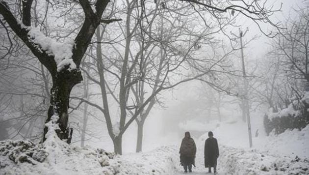 Locals walk on a snow-covered road amid fog at Faqir Gujri on the outskirts of Srinagar.(PTI) Locals walk on a snow-covered road amid fog at Faqir Gujri on the outskirts of Srinagar.(PTI)