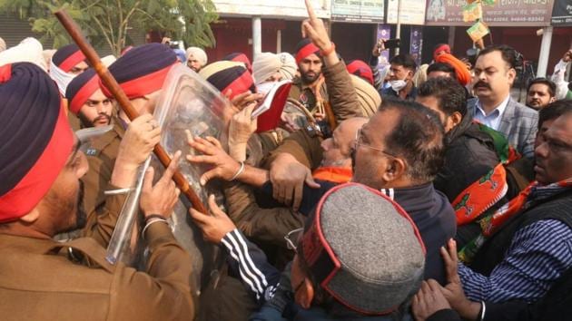 BJP members arguing with police personnel when they asked them to leave the venue after farm activists disrupted their function to celebrate the birth anniversary of former PM Atal Bihari Vajpayee in Bathinda on Friday.(Sanjeev Kumar/HT)