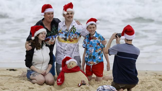 A family poses for a photograph at Sydney’s Bondi Beach, in Australia on December 25. (Mark Baker / AP) A family poses for a photograph at Sydney’s Bondi Beach, in Australia on December 25. (Mark Baker / AP)