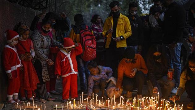 Children seen dressed in Santa Claus outfits while people light candles outside Sacred Heart Cathedral on the occasion of Christmas, in New Delhi, India on December 25. Sacred Heart Cathedral remained closed on Christmas Day in the wake of the coronavirus outbreak. (Biplov Bhuyan / HT Photo) Children seen dressed in Santa Claus outfits while people light candles outside Sacred Heart Cathedral on the occasion of Christmas, in New Delhi, India on December 25. Sacred Heart Cathedral remained closed on Christmas Day in the wake of the coronavirus outbreak. (Biplov Bhuyan / HT Photo)