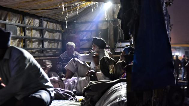 Farmers rest at a makeshift camp built inside a truck at Singhu border near New Delhi on December 3. On bone-chilling winter nights in Delhi, elderly farmers slept inside the camps while the younger farmers slept under tractor-trolleys. (Sanchit Khanna / HT Photo) Farmers rest at a makeshift camp built inside a truck at Singhu border near New Delhi on December 3. On bone-chilling winter nights in Delhi, elderly farmers slept inside the camps while the younger farmers slept under tractor-trolleys. (Sanchit Khanna / HT Photo)