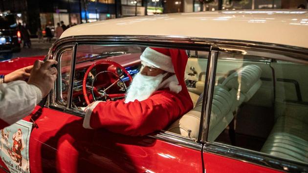 Rob Holtzapfel, a member of a vintage car group dressed as Santa Claus, sits in a 1959 Cadillac during a photoshoot with the car owner (L) along a street lined with Christmas-themed light decorations in Marunouchi district of Tokyo, Japan on December 25. (Philip Fong / AFP) Rob Holtzapfel, a member of a vintage car group dressed as Santa Claus, sits in a 1959 Cadillac during a photoshoot with the car owner (L) along a street lined with Christmas-themed light decorations in Marunouchi district of Tokyo, Japan on December 25. (Philip Fong / AFP)