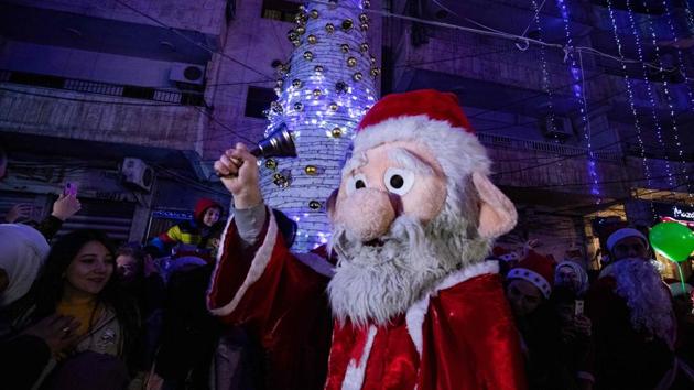 A man dressed as Santa Claus rings a bell during Christmas celebrations in Qamishli, Syria on December 24. (Delil Souleiman / AFP) A man dressed as Santa Claus rings a bell during Christmas celebrations in Qamishli, Syria on December 24. (Delil Souleiman / AFP)