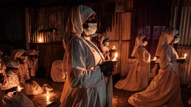 Worshippers of Legio Maria wearing face masks attend the Christmas prayer at their church in the Kibera, Nairobi, Kenya on December 25. (Yasuyoshi Chiba / AFP) Worshippers of Legio Maria wearing face masks attend the Christmas prayer at their church in the Kibera, Nairobi, Kenya on December 25. (Yasuyoshi Chiba / AFP)