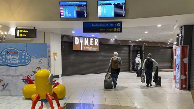 Passengers walk through the deserted international departure international terminal at Johannesburg's OR Tambo airport on December 21 as an increasing number of countries around the world restrict travel from Britain and elsewhere, including South Africa, amid concerns about new variants of the coronavirus. (Jerome Delay / AP)