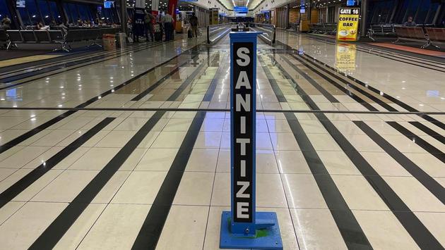 A hand sanitizing pump stands in the middle of a near empty terminal at OR Tambo airport on December 21. Normally, the airport is packed solid this time of year. Travellers pushing trolleys snake through lines to the check-in counters, followed by more long lines for security and again for immigration. Even the business lounges are overcrowded and it can take 20 minutes to pay for a duty-free bottle of wine. Not this Christmas. (Jerome Delay / AP)