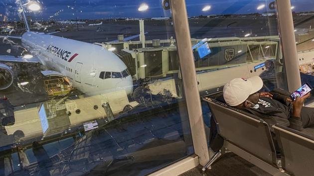 Passengers wait to board their Air France flight to Paris at OR Tambo airport on December 21. The international terminal was empty and most shops closed, aside from the duty-free perfume, alcohol and tobacco store, a sunglasses franchise and a listless electronics shop. (Jerome Delay / AP)