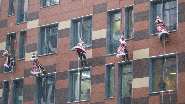 Russian emergency rescue workers dressed as Ded Morozes (Santa Claus or Father Frost) greets children as they scale the wall of a children hospital during Christmas celebrations in Russia on December 25. (Pavel Golovkin / AP) Russian emergency rescue workers dressed as Ded Morozes (Santa Claus or Father Frost) greets children as they scale the wall of a children hospital during Christmas celebrations in Russia on December 25. (Pavel Golovkin / AP)