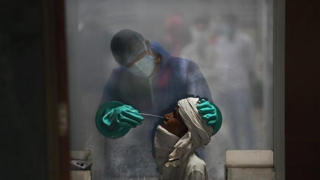 A health worker takes a nasal swab of a person for a Covid-19 test at a hospital in New Delhi, India. (AP) A health worker takes a nasal swab of a person for a Covid-19 test at a hospital in New Delhi, India. (AP)