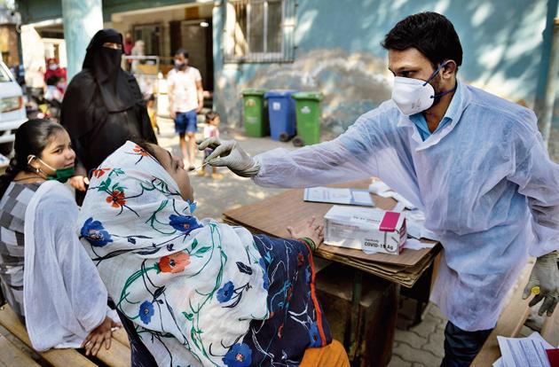 A BMC health worker takes a swab sample of a resident in Khar on Saturday. (Satish Bate/HT Photo) A BMC health worker takes a swab sample of a resident in Khar on Saturday. (Satish Bate/HT Photo)