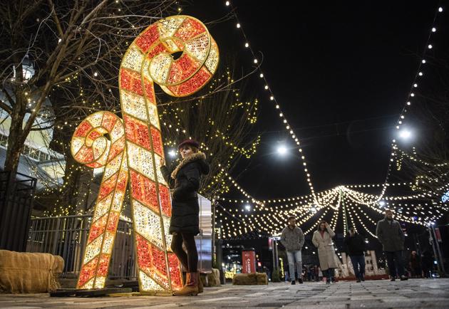 A person poses for photos beside illuminated candy canes during "Lights at Lansdowne" at Lansdowne Park in Ottawa, Ontario. The site was intended to be the venue for the Ottawa Christmas Market, which was cancelled due to the Covid-19 pandemic. (AP Photo/Justin Tang) A person poses for photos beside illuminated candy canes during "Lights at Lansdowne" at Lansdowne Park in Ottawa, Ontario. The site was intended to be the venue for the Ottawa Christmas Market, which was cancelled due to the Covid-19 pandemic. (AP Photo/Justin Tang)