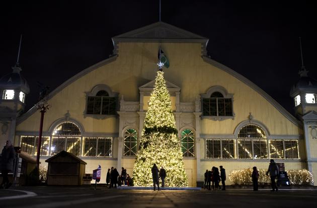 People pose for photos beside a giant Christmas tree during "Lights at Lansdowne" at Lansdowne Park in Ottawa, Ontario on Christmas Day The site was intended to be the venue for the Ottawa Christmas Market, which was cancelled due to the Covid-19 pandemic. (AP photo/Justin Tang) People pose for photos beside a giant Christmas tree during "Lights at Lansdowne" at Lansdowne Park in Ottawa, Ontario on Christmas Day The site was intended to be the venue for the Ottawa Christmas Market, which was cancelled due to the Covid-19 pandemic. (AP photo/Justin Tang)